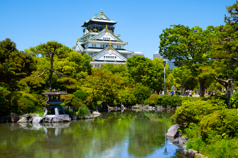 Vue pittoresque du château d'Osaka entouré de son jardin et d'un étang, mettant en valeur l'architecture historique japonaise.